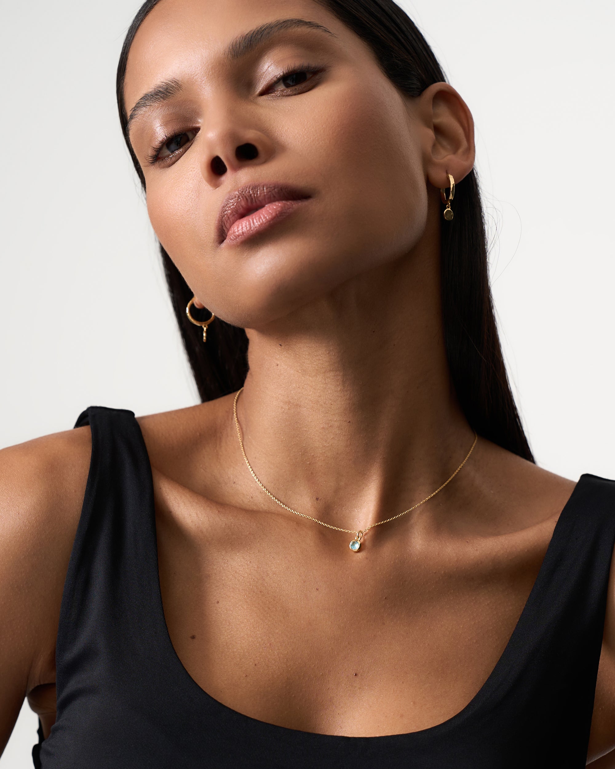 Model is wearing Azora gold vermeil blue topaz December birthstone necklace