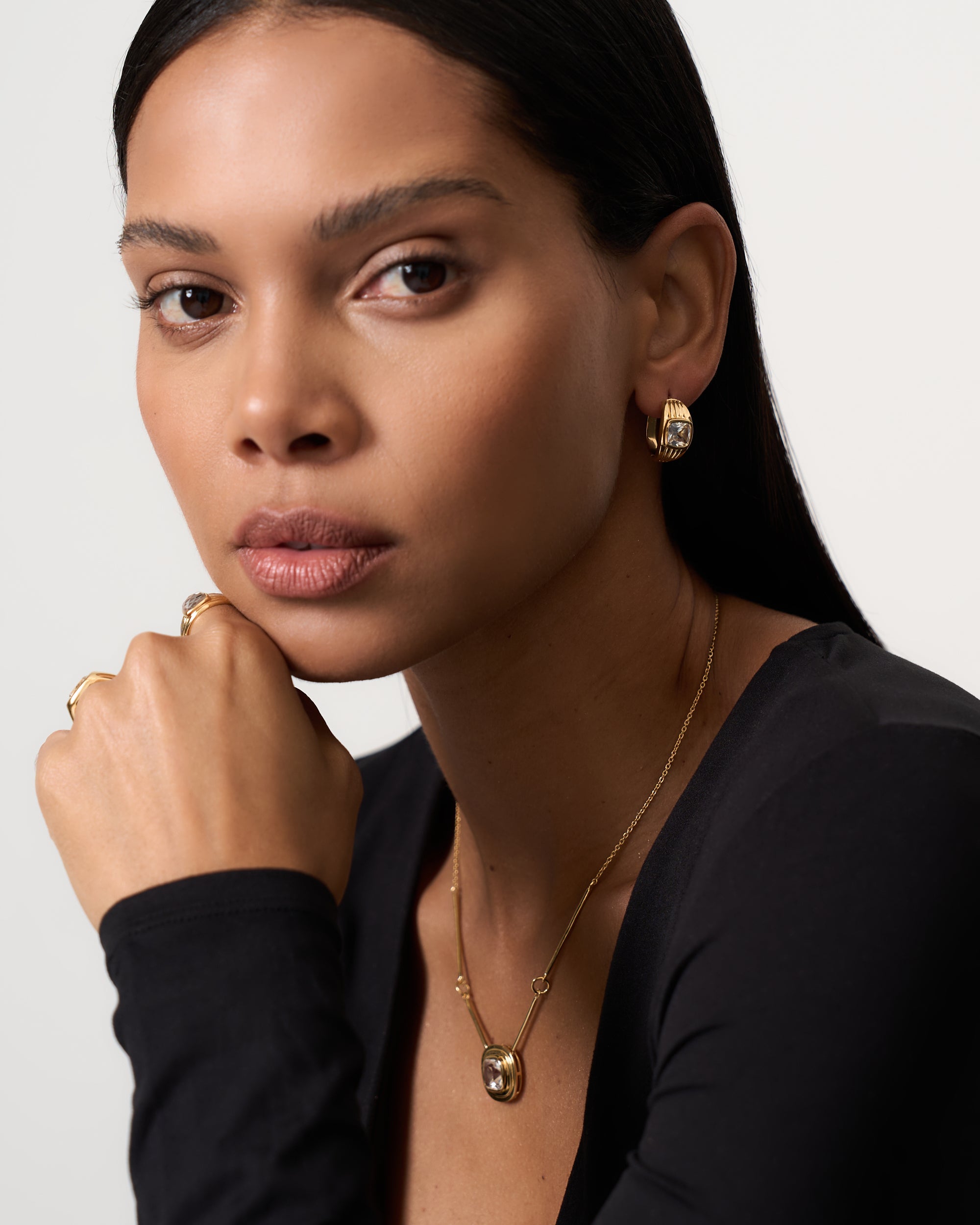 Model wearing gold vermeil textured higgie earrings with a white sapphire.