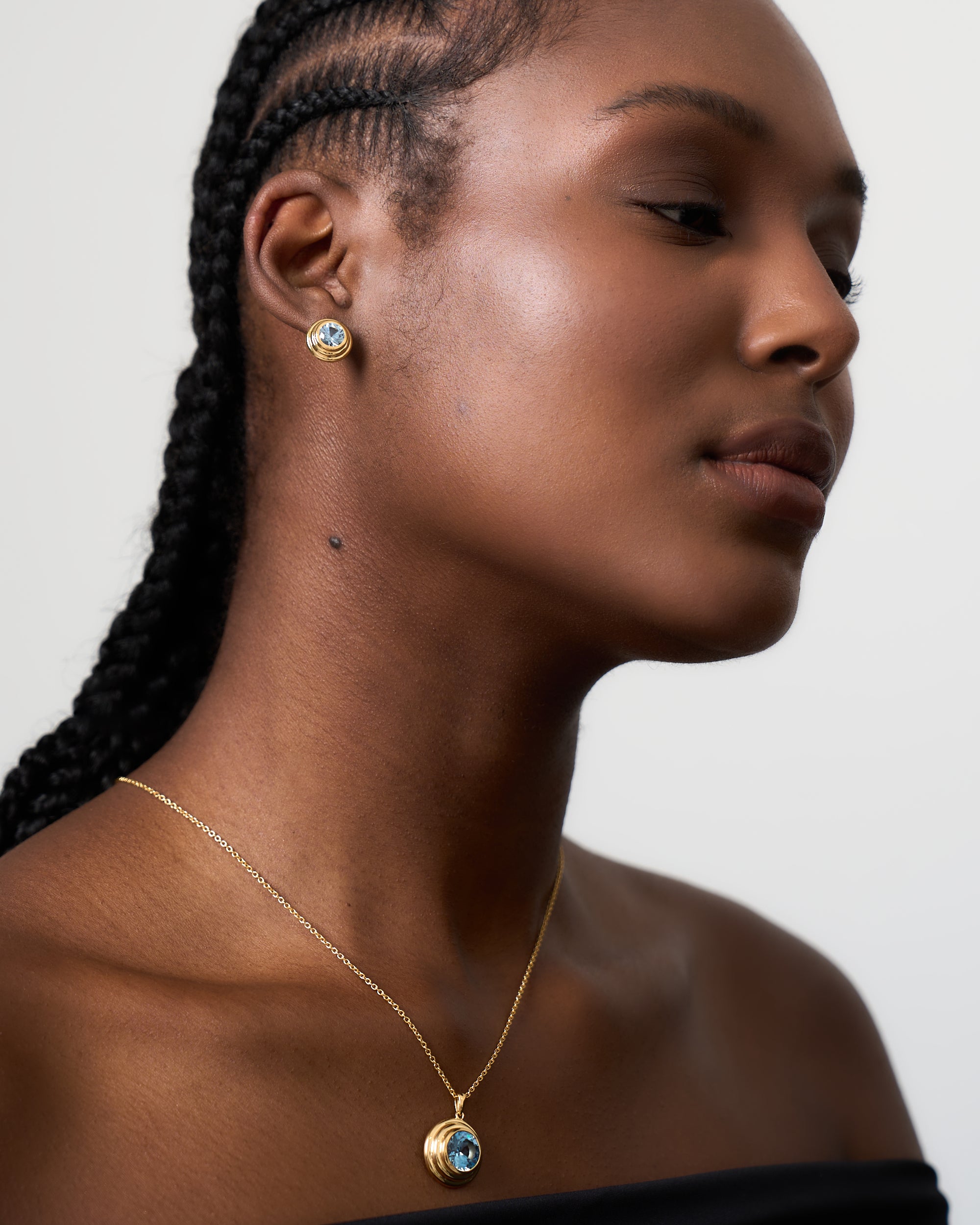 Model wears Azora aquamarine solarium stud earrings.