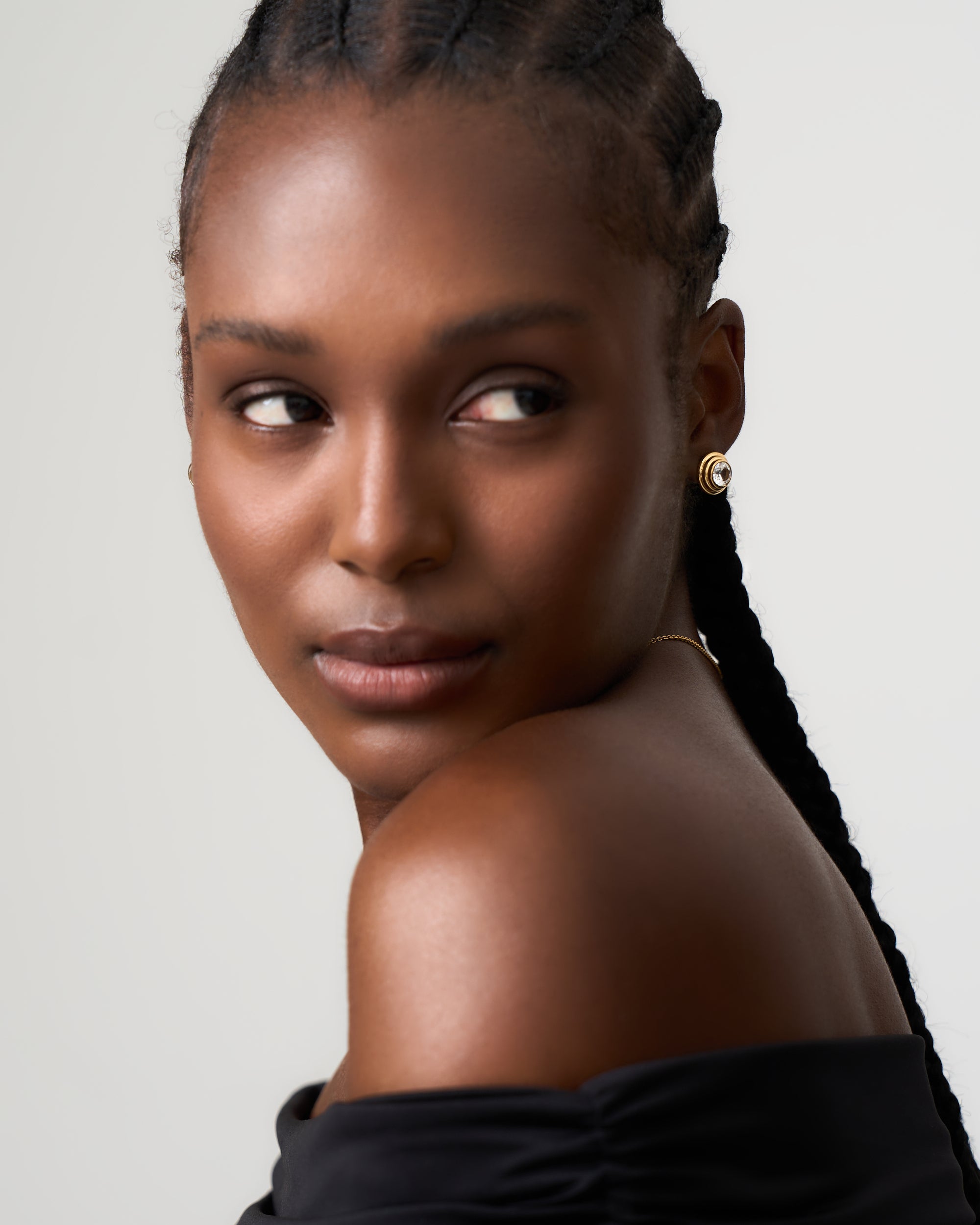 Model wears white sapphire solarium earrings by Azora Jewellery