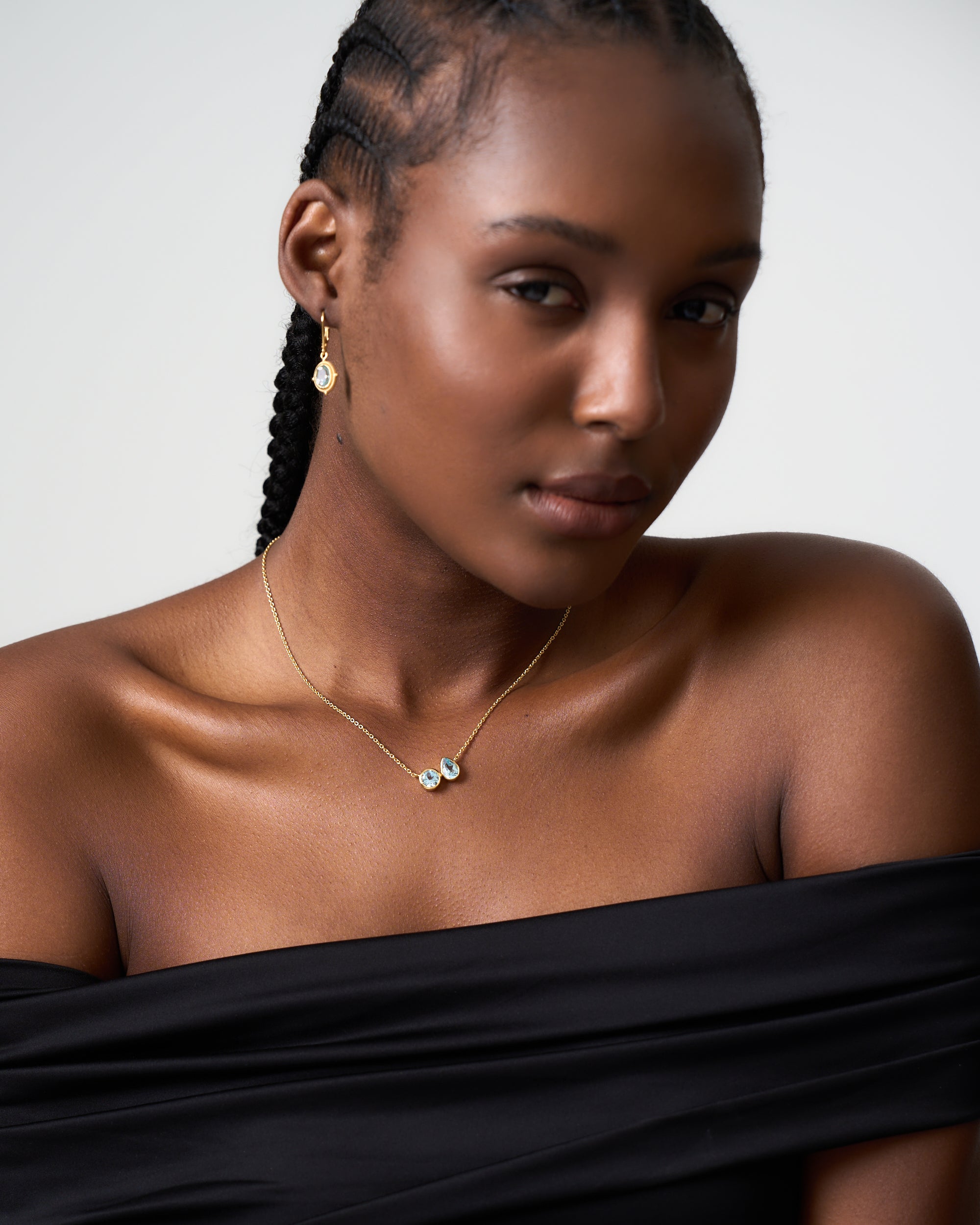 Model wears a blue topaz cluster pendant by Azora Jewellery paired with drop earrings