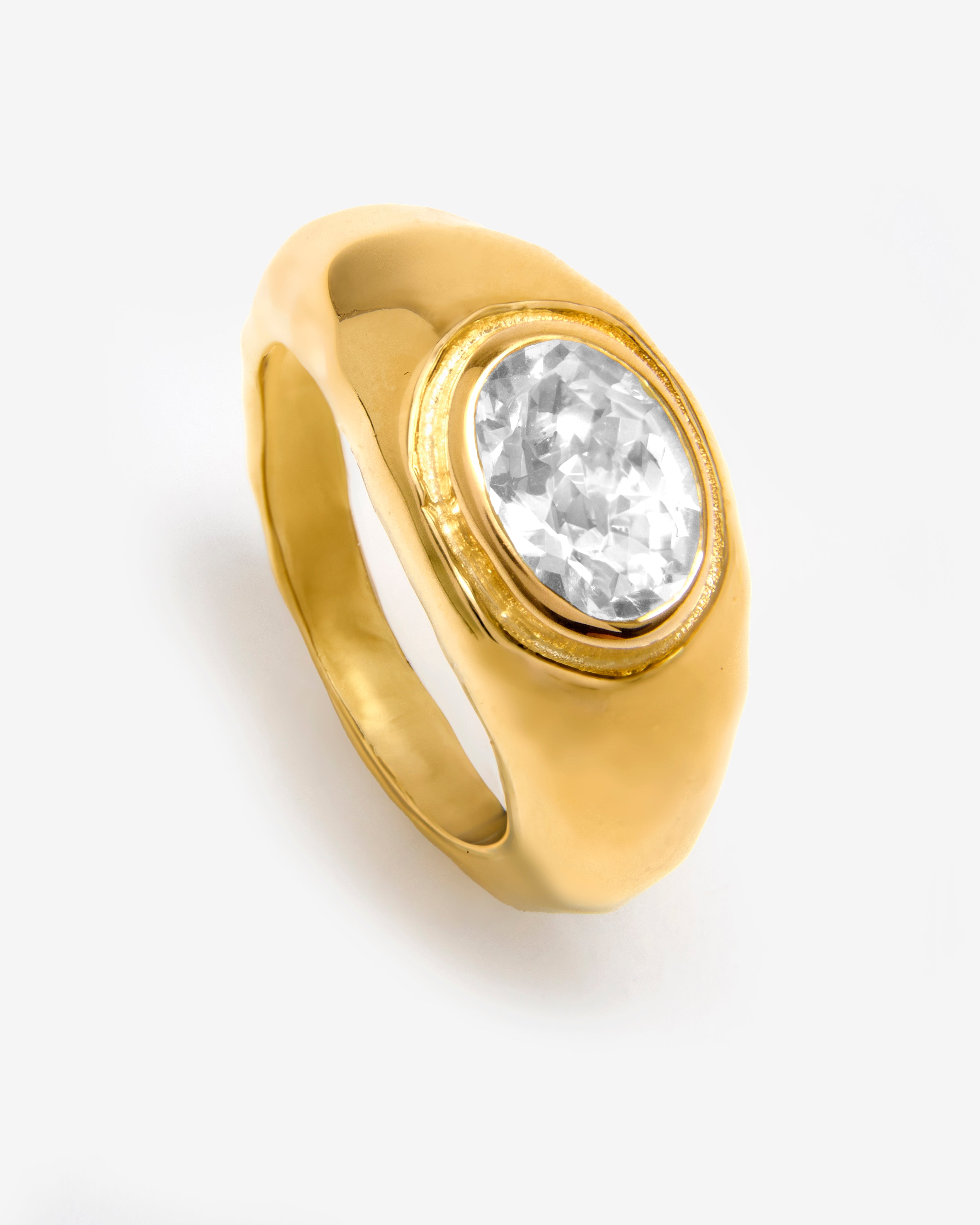 A gold vermeil textured band ring with a central white sapphire gemstone, set in a hammered gold vermeil band by Azora Jewellery.