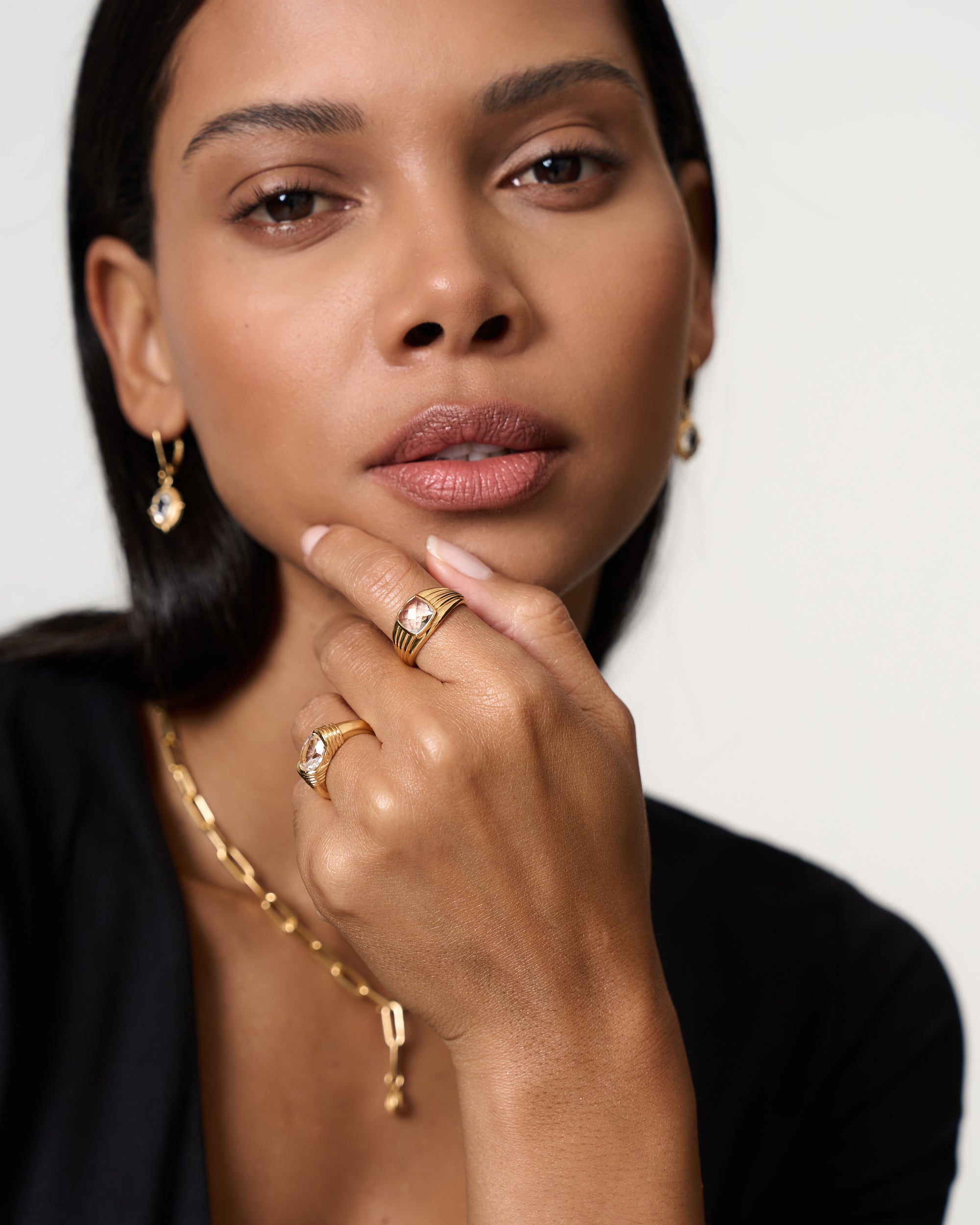 Model wears white sapphire hammered ring paired with a selection of gold vermeil jewellery by Azora.