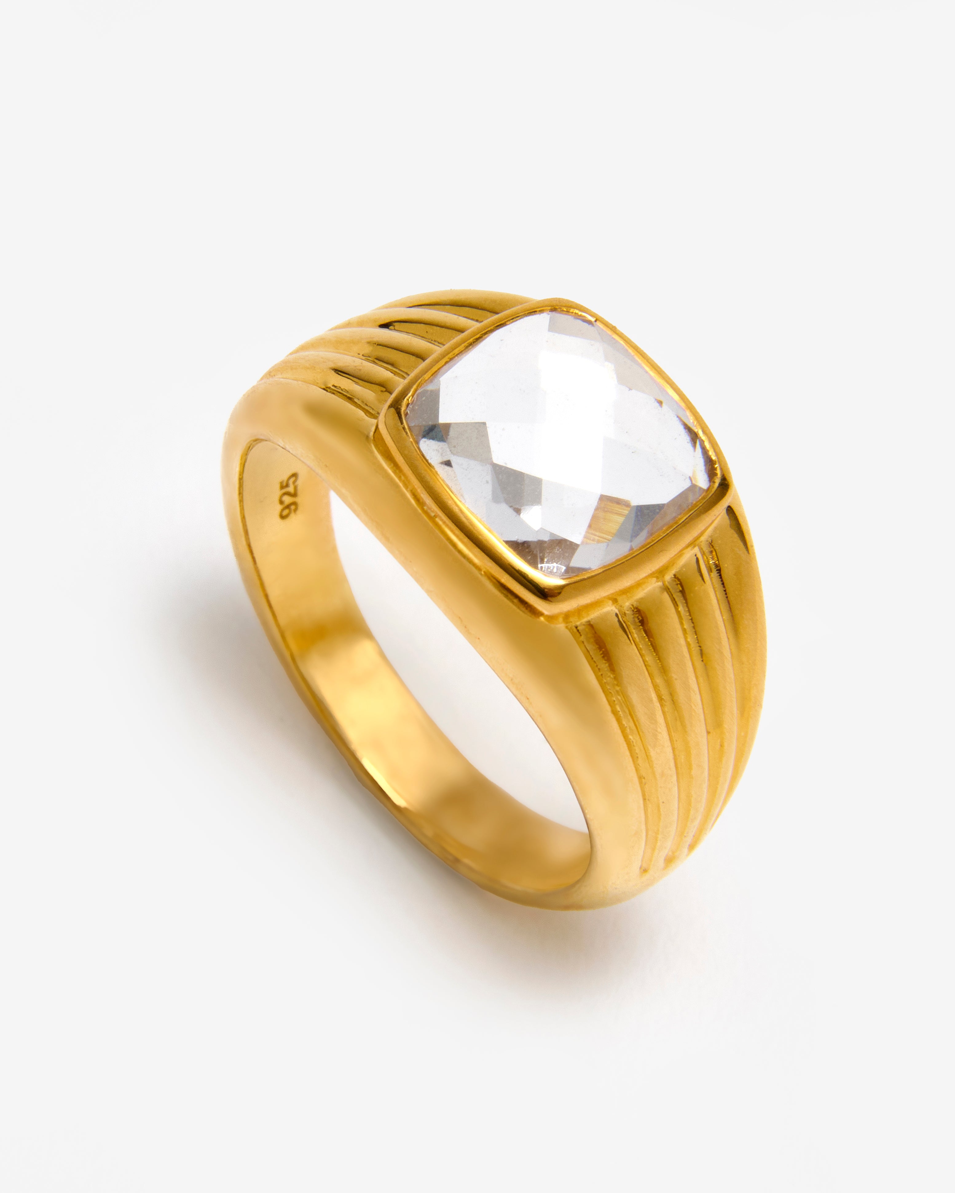 An 18k gold vermeil band ring with a textured design and a lab-grown white sapphire accent on top.