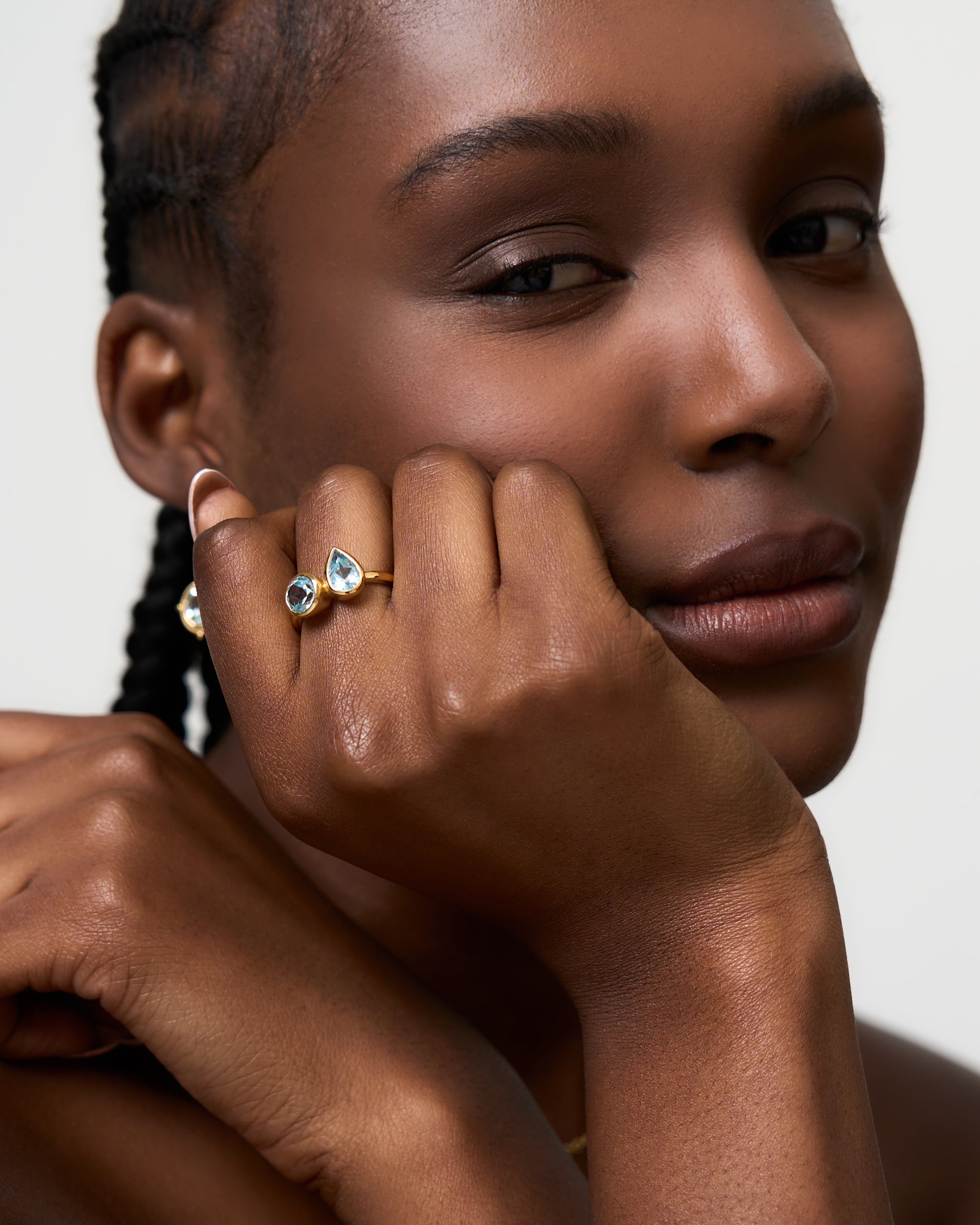 Model wears a blue topaz and gold vermeil ring by Azora Jewellery