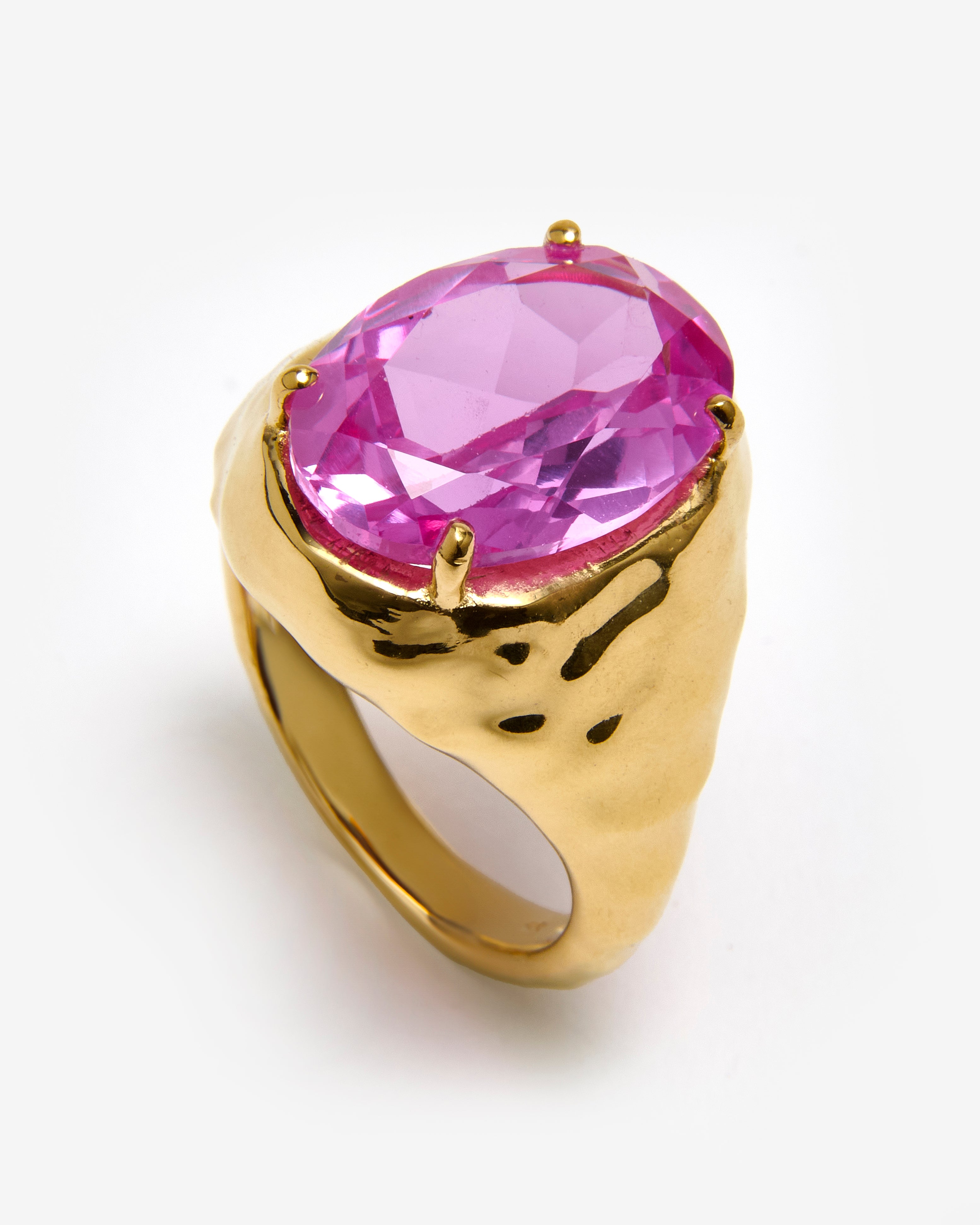 A gold vermeil chunky statement ring with a vibrant pink tourmaline center stone set on a textured band.